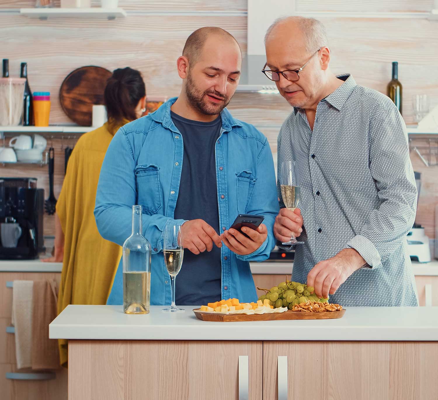 Two men drinking wine looking at phone